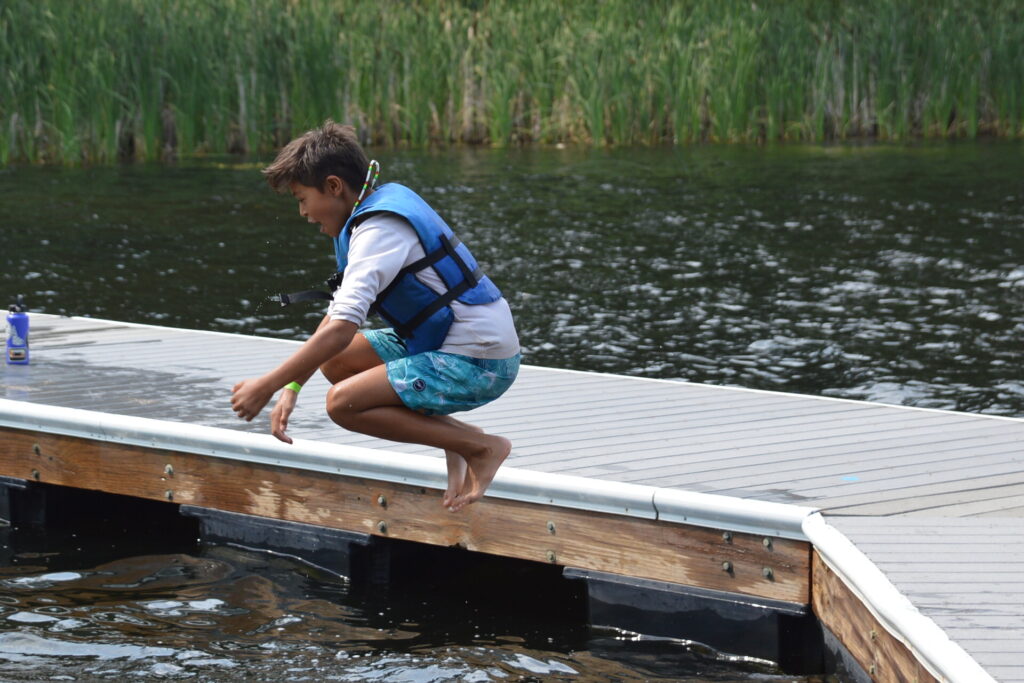 Boy jumping off dock